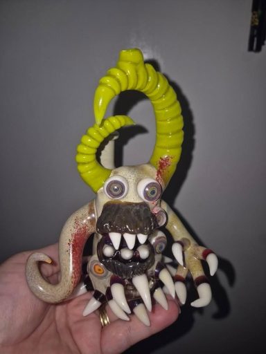 A distinctive creature figure with claws, fangs, and yellow spiraled horns.